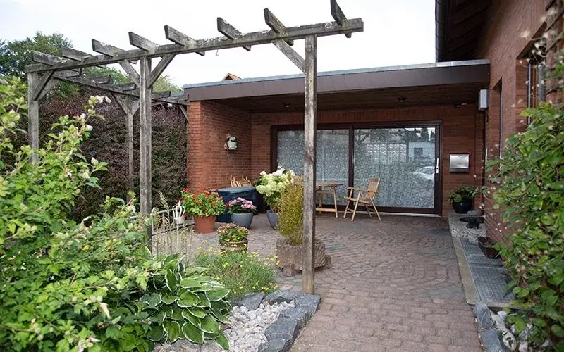 Separater Eingang der Ferienwohnung mit Pergola, Pflasterhof und überdachtem Sitzplatz