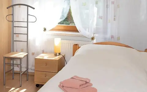 Schlafzimmer mit Nachttisch, Herrendiener und bereitgelegten Handtüchern
