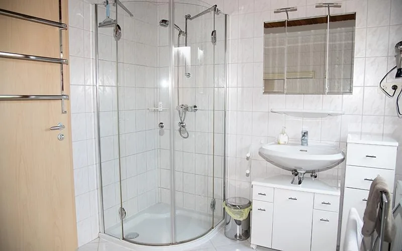 Tageslichtbad mit Eckdusche, Waschbecken und Spiegelschrank
