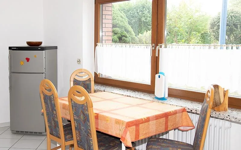 Essplatz am Fenster mit Blick in den Garten, daneben der Kühlschrank