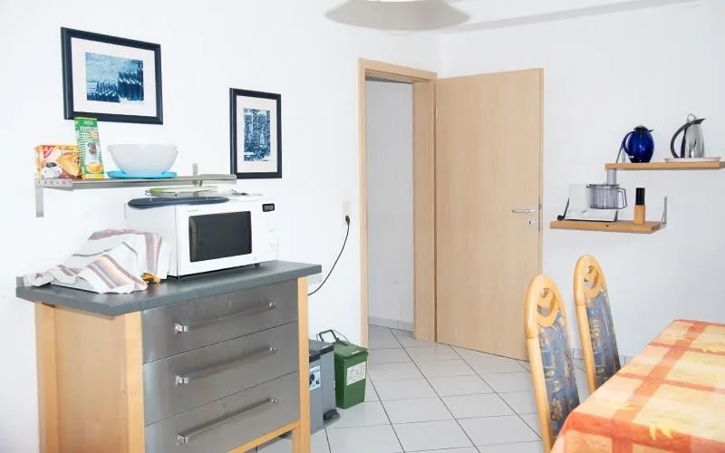 Küche mit Mikrowelle und Arbeitsfläche, Durchgang zum Flur