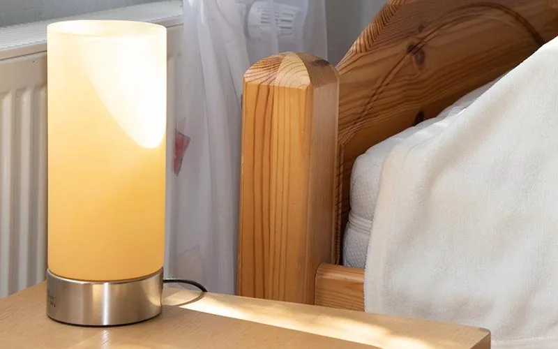Nachttischlampe am Bett im Abendlicht