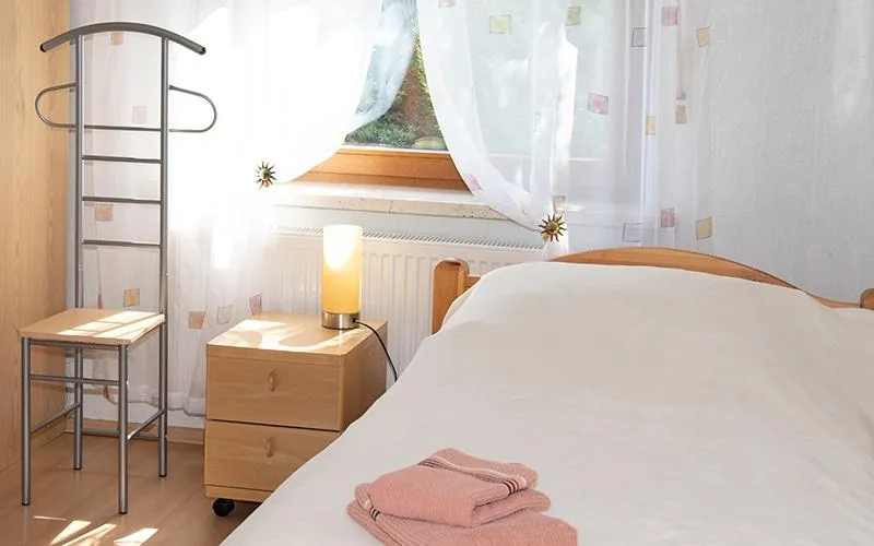 Schlafzimmer mit Nachttisch, Herrendiener und bereitgelegten Handtüchern